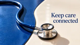 A blue stethoscope crosses blue and ivory surfaces beside the words “Keep care connected.”
