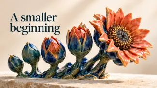 Coral and blue ceramic buds open into a flower beneath the words “A smaller beginning.”