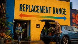 A mature couple loads plants into a blue crossover beneath a colorful mural reading “Replacement Range,” with arrows pointing in both directions.