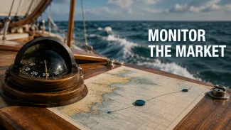 A compass and navigation chart on a sailboat beside the words “Monitor the Market” as waves move in the background.