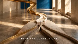 Brass and stone tracks converge and branch inside a sunlit gallery, representing two spouses’ financial paths joining one household tax plan.