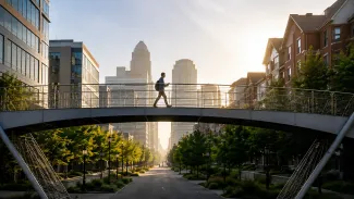 A person crosses a pedestrian bridge connecting an office district with a residential neighborhood.