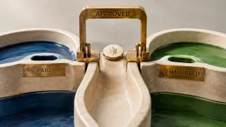 A ceramic-and-brass mechanism separates expenses marked Paid, Approved, and Reimbursed.