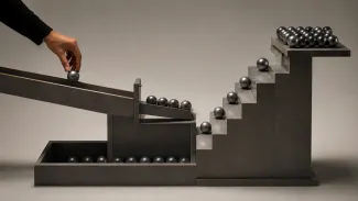 A hand releases metal spheres toward a temporary holding gate while a separate staircase leads to a growing reserve.