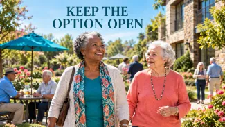 Two older women walk through a retirement-community courtyard beneath the words “Keep the Option Open.”