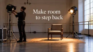 A technician adjusts one stage light while another keeps an empty chair illuminated, beneath the words “Make room to step back.”