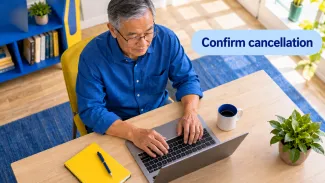 An older man uses a laptop at a bright desk beneath the words “Confirm cancellation.”