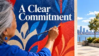 An older woman paints a colorful mural beside a waterfront beneath the words “A Clear Commitment.”