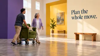 An older woman walks beside a helper moving her green armchair into a bright new setting, with the words “Plan the whole move.”