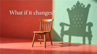 A wooden chair stands beside the shadow of a grander chair beneath the words “What if it changes?”
