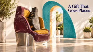 A guitar case rests on a sculptural car seat beside an open turquoise arch, with the words “A Gift That Goes Places.”
