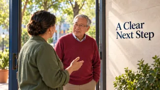 An older man talks with a helper in a sunlit doorway beside the words “A Clear Next Step.”