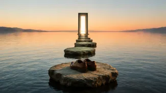 Work shoes rest beside stepping stones leading across calm water to a glowing open doorway.