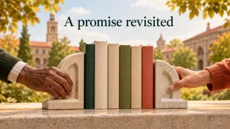 Older and younger hands adjust stone bookends around books with a university campus behind them.
