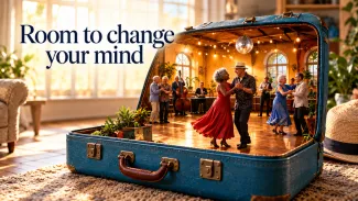 An open blue suitcase contains a miniature dance hall with older couples beneath the words “Room to change your mind.”