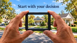 Hands hold a viewfinder framing one home within a neighborhood beneath “Start with your decision.”