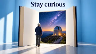 An older adult looks through a giant open book toward an observatory and starry sky, beneath the words “Stay curious.”