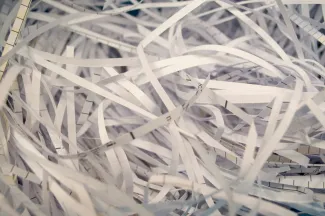 a pile of white shredded paper sitting on top of a table by Mahen Rin courtesy of Unsplash.