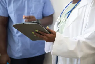a doctor showing a patient something on the tablet by Nappy courtesy of Unsplash.