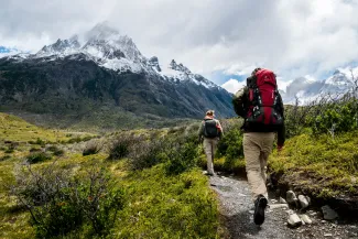 two person walking towards mountain covered with snow by Toomas Tartes courtesy of Unsplash.