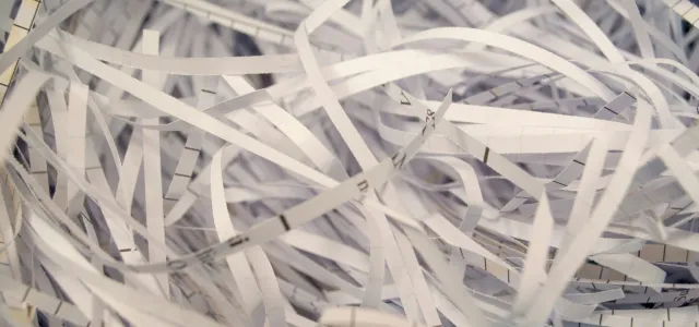 a pile of white shredded paper sitting on top of a table by Mahen Rin courtesy of Unsplash.