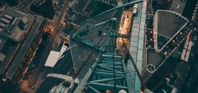 person standing on gray steel frame on top of building by Yeshi Kangrang courtesy of Unsplash.
