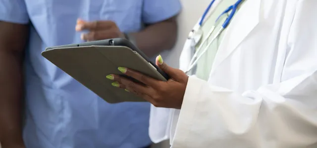 a doctor showing a patient something on the tablet by Nappy courtesy of Unsplash.