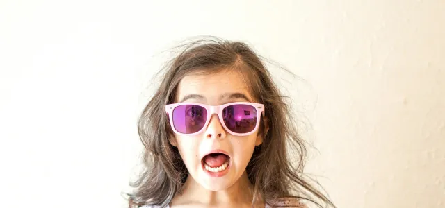 girl in white and purple floral crew neck shirt wearing blue framed sunglasses by Thomas Park courtesy of Unsplash.